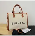 Retro Canvas-Einkaufstasche in Beige mit braunen Lederriemen und schwarzem Schriftzug - Groß / Braun