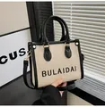 Minimalistische beige Canvas-Tasche mit schwarzem Lederbesatz und BULAIDAI-Logo - Klein / Schwarz