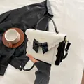 Elegante bolso de mano en contraste con lazo negro y crema y detalles dorados - Negro