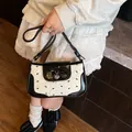 Chic black and white bow handbag with heart pendant for women in a stylish outfit - White