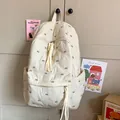 Cream quilted backpack featuring brown bow embroidery and cotton rope zipper tassels - No Charms / White