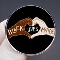 Κυκλική μεταλλική κονκάρδα Black Lives Matter με χέρια σε σχήμα καρδιάς σε γκρίζο φόντο - Στυλ Black Lives Matter