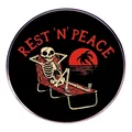 Skeleton relaxing on a beach chair enamel pin with Rest 'N' Peace text and sunset design - Rest In Peace Skull Style