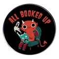 Spilla All Booked Up con diavoletto rosso che legge seduto su una poltrona verde - Stile Demone che Legge (ALL BOOKED UP)