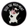 Cartoon cow enamel pin with Seize The Moo-ment slogan in a circular metal design - Seize The Opportunity