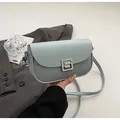 Detail of light blue saddle bag featuring mesh texture and silver square metal buckle - Blue