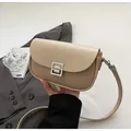 Detail of beige saddle bag showing woven texture and square hollow metal buckle - Khaki