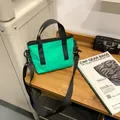 Versatile vibrant green commuter crossbody bag with black adjustable strap and top handle - Teal