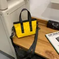 Chic yellow nylon shoulder bag with adjustable wide strap for urban commuting fashion - Yellow