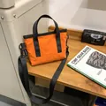 Minimalist orange lightweight crossbody bag with black straps for city commuting - Orange