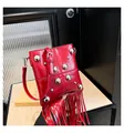 Detalle del bolso rojo brillante con remaches plateados y flecos de borlas largas suaves - Rojo