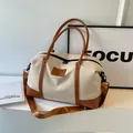 Cream canvas travel bag with brown leather trim and adjustable shoulder strap for gym - Brown