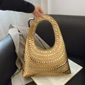 Metallic gold crescent handbag with silver studs on a handle and sleek faux leather finish - Gold
