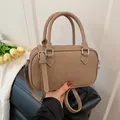 Khakibraune Boston-Tasche aus Leder mit Litschimuster, Silberbeschlägen und Gurt - Khaki