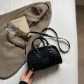 Black vintage Boston bag with embossed lettering and adjustable shoulder strap - Black