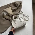 Creamy white Boston handbag with embossed ATN letters and silver hardware detailing - Off White