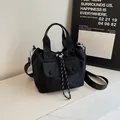 Bolso saco negro versátil de tela Oxford con cordón y bolsillo frontal de dos hebillas - Negro