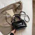 Bolso de mano negro en cuero grabado con remaches metálicos y correa ajustable - Negro (Sin Colgante)