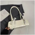 Minimalistische cremeweiße Lackleder-Achseltasche mit Spitzenschleife und Herzanhängern - Weiß