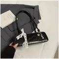 Minimalistische schwarze Lackleder-Schultertasche mit weißer Spitzenschleife und Herzanhänger - Schwarz