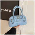 Close-up of light blue shell bag with leather texture and double metal zippers - Blue