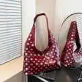 Red leather hobo tote bag with silver studs and single strap in a minimalist setting - Red
