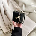 Mini black quilted leather box bag with gold ball chain and floral detail on the front - Black