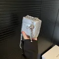 Mini silver quilted crossbody bag with camellia buckle and metallic chain strap - Silver