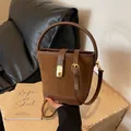 Bolso cubo marrón caramelo con cierre dorado y correa ajustable para mujer - Marrón