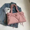 Roze canvas draagtas met decoratieve strikken en geplooide handvatten op denim - Roze