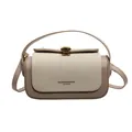 Detalle del bolso beige minimalista con contraste, textura tejida y hebilla dorada - Blanco Roto