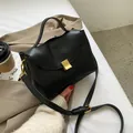 Minimalistische schwarze Handtasche aus Kunstleder mit Goldschließe und Schultergurt - Schwarz