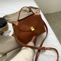 Minimalistische karamellbraune Umhängetasche aus Leder mit matter goldener Schnalle und Gurt - Braun