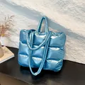 Quilted down tote bag in metallic bright blue finish with puffer texture and dual handles - Blue