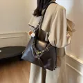 Bolso tote grande de cuero marrón oscuro con herrajes dorados y colgante de béisbol al hombro - Café