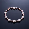 Elegantes Armband mit Roségoldbeschichtung und birnenförmigen weißen Kristallen - Roségold