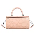 Close-up of pink cylindrical bag featuring hibiscus floral embossing and silver hardware - Pink