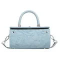 Close-up of light blue cylindrical bag featuring intricate floral embossed leather texture - Blue