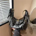 Retro black leather croissant bag with rivets and gold-toned hardware in vintage style - Black