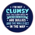 Broche redondo de metal azul oscuro con cita de humor I'm Not Clumsy y tipografía blanca - No soy torpe