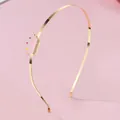 Détail d'un serre-tête en métal doré orné d'une couronne rose aux points multicolores - Forme de couronne