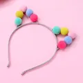 Detail of colorful plush pom-poms on a glittery silver cat ear headband - Candy Color Pom-pom Headband