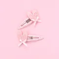 Pair of pink glitter ballet shoe hair clips with ribbon bows on a matching pink background - Pink Ballet Shoes