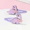 Dettaglio di due fermagli per capelli a forma di dinosauro viola con fiocchetti - Viola
