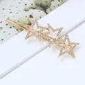 Détail d'une pince à cheveux dorée ornée d'étoiles en strass brillants et élégants - Pince à cheveux étoile creuse strass