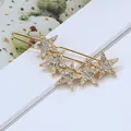 Détail d'une pince à cheveux dorée à cinq étoiles sertie de strass brillants et élégants - Pince à cheveux étoile strass