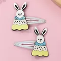 Detailed view of two cute bunny hair clips with blue sequins on pink background - Little Rabbit / White