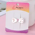 White bow hair clip with pink moon patterns and heart gemstone on display card - Bow Hch252-1