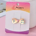 Golden bow hairpin with blue moon and pink heart charms on a pink presentation card - Matte Gold Bow knot