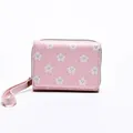 Pink short wallet for women featuring white smiling star prints and a wrist strap - Pink
